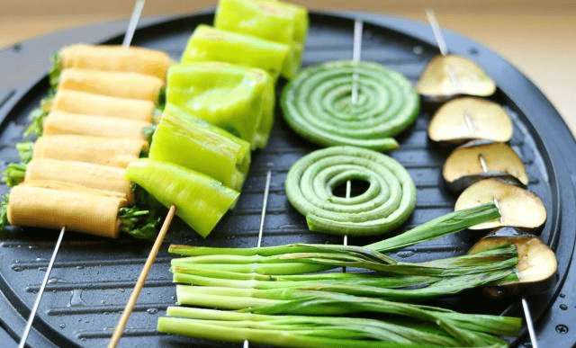 3,用电饼铛就可以烤,很方便,打开,刷上一层薄油,放上串好的蔬菜串