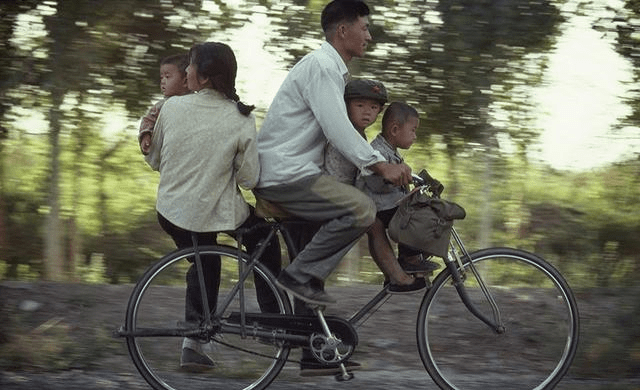 80年代上海路边,骑着自行车的快乐一家人.