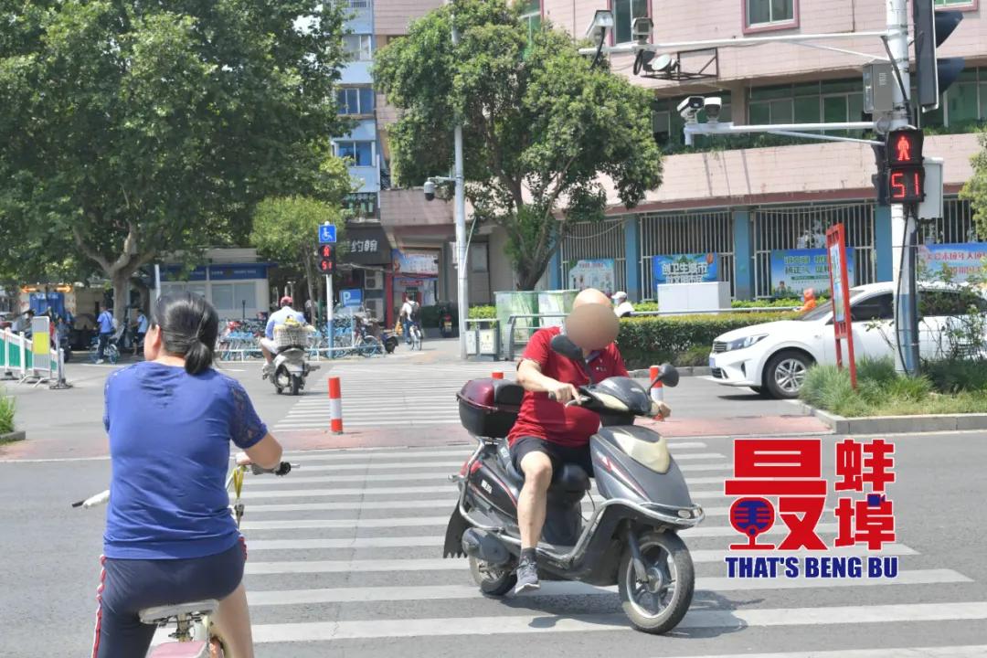 一光头男子骑电动车 闯红灯