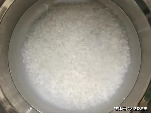 2.大米泡好后把水倒掉,大米里加入1勺食用油,同大米拌匀