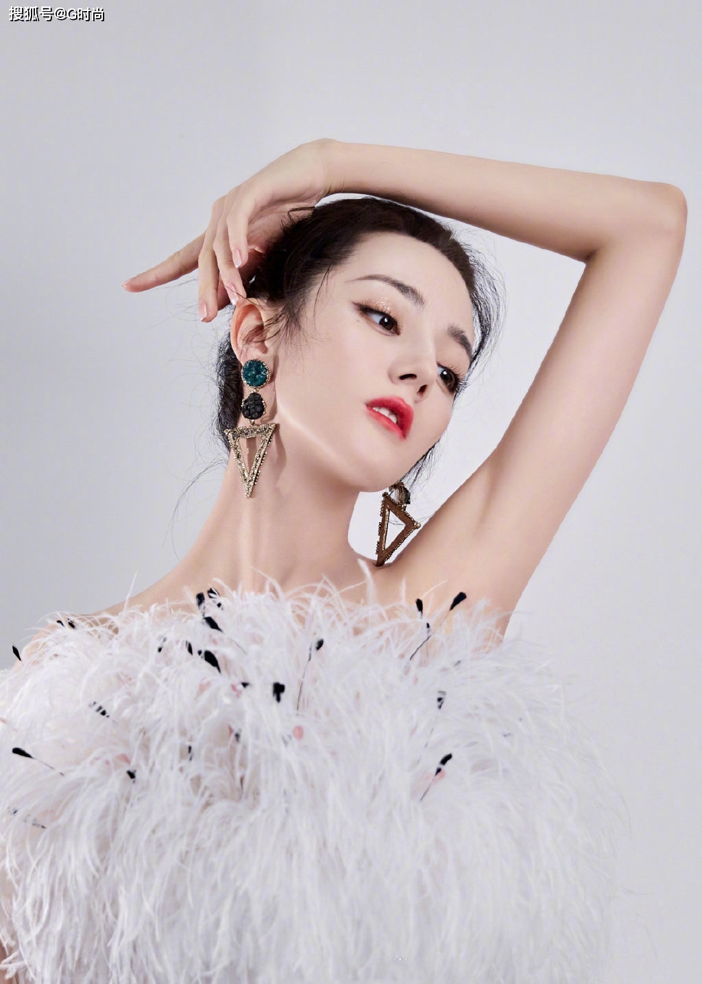 迪丽热巴身穿白色羽毛短裙,身材曼妙,妆容精致