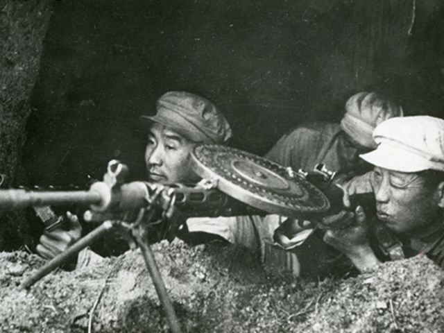 志愿军战士在坑道口向敌人射击