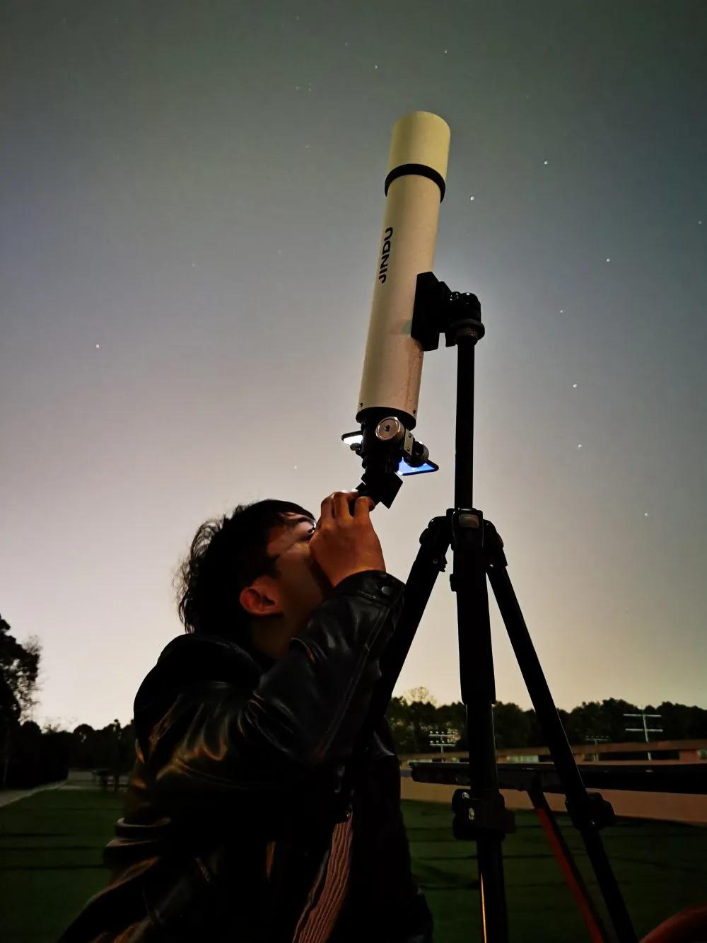 学生使用天文望远镜观测星空