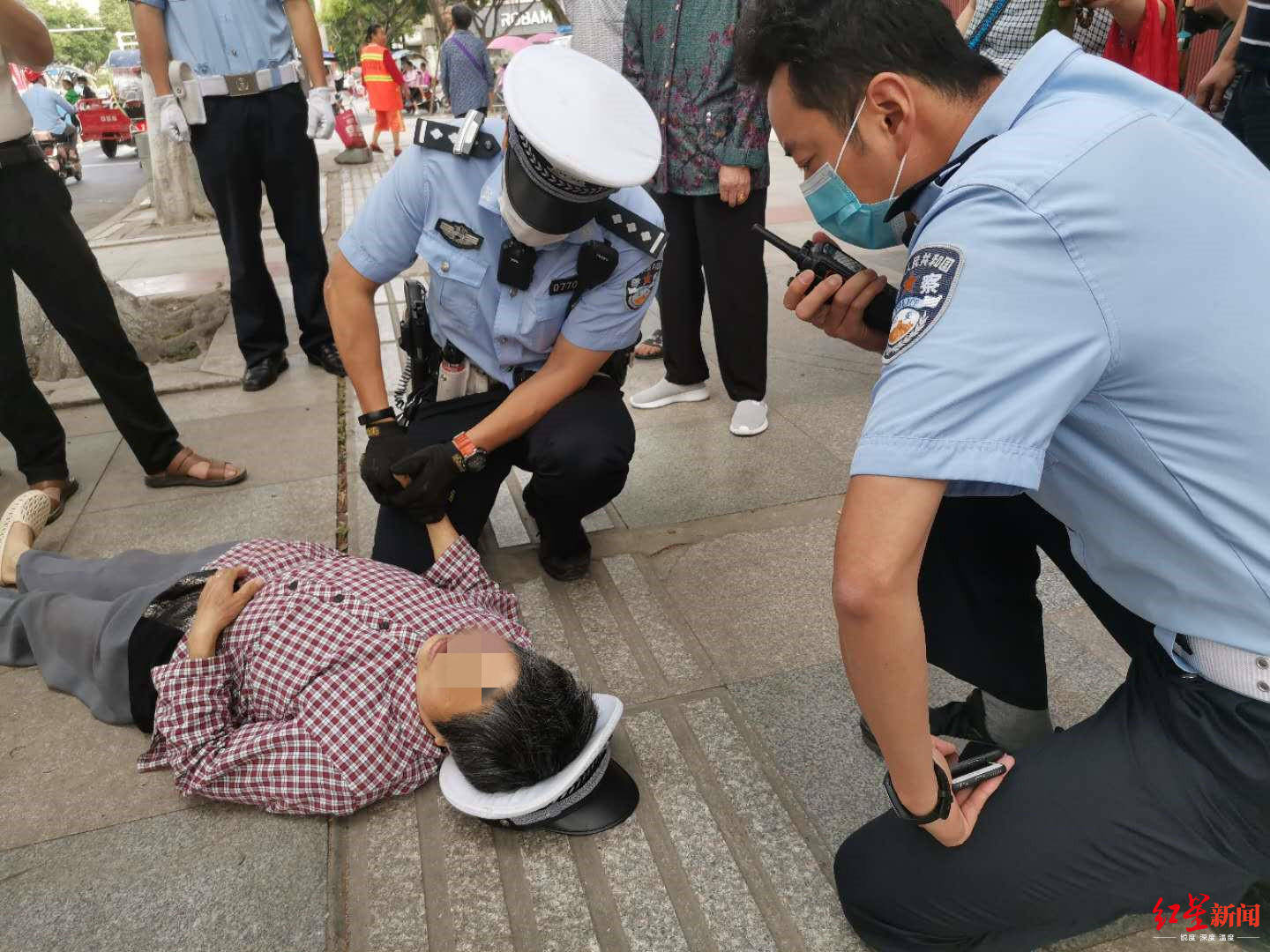 70岁老人早高峰晕倒路边 交警取下警帽垫高她头