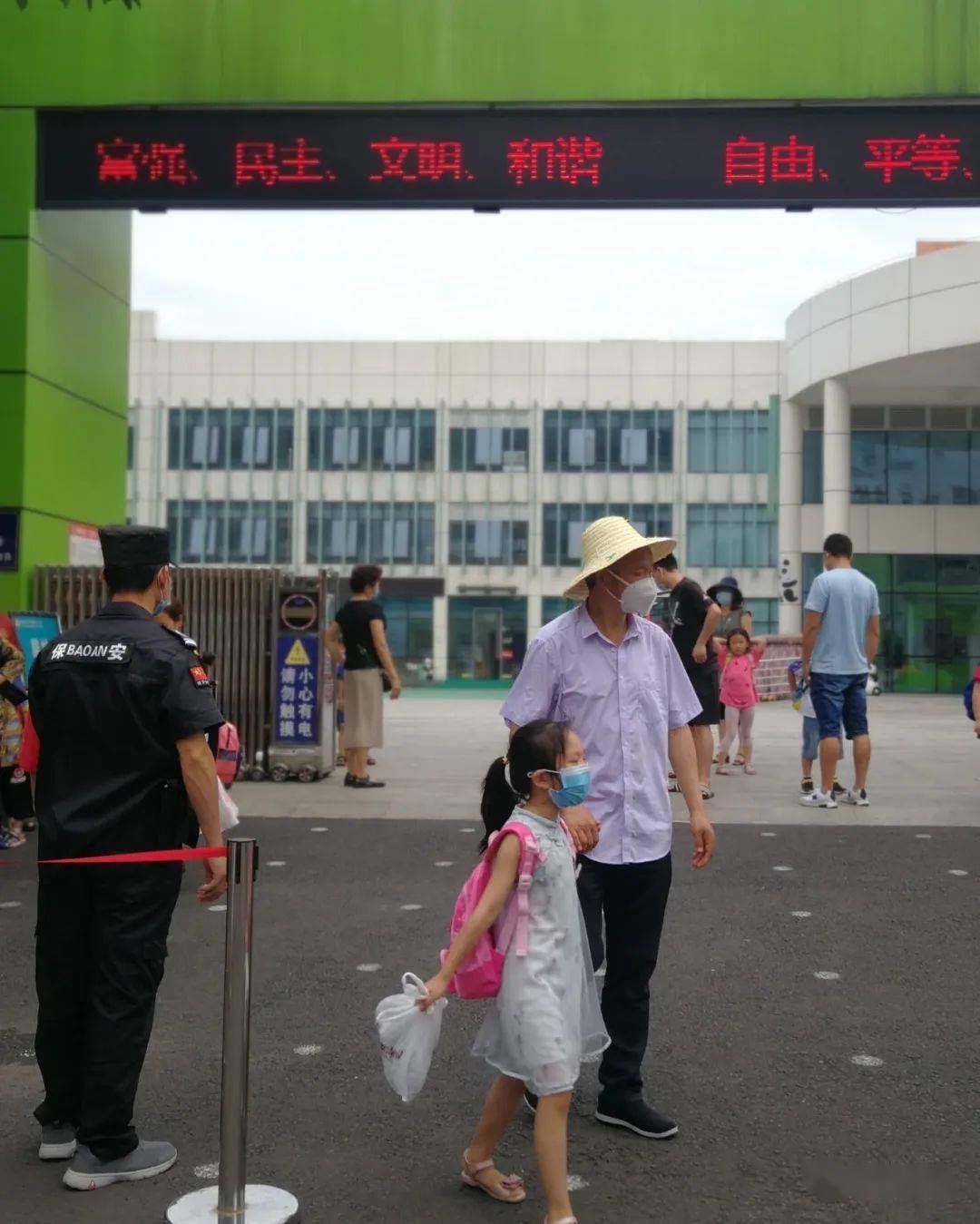 雅安市实验幼儿园门口,家长戴着口罩接孩子放学