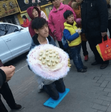 搞笑GIF:哥们为求女友原谅,街头手捧鲜花跪搓衣板