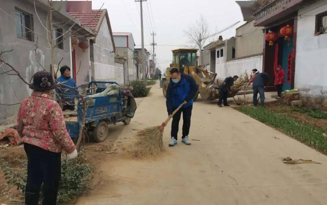 秦晓博(左三)与干部群众一起清理村内垃圾