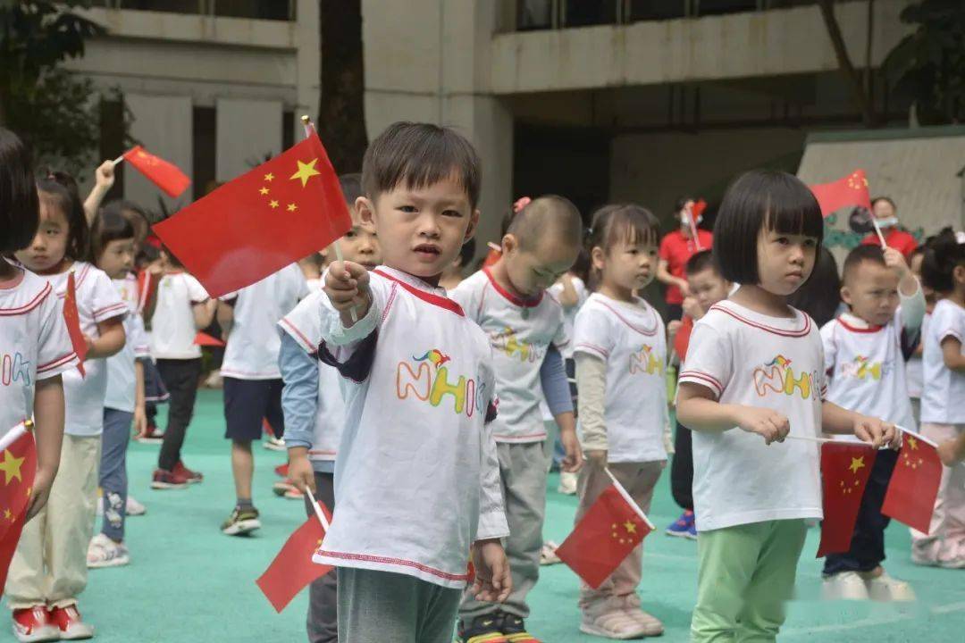 一张张笑脸在国旗下绽放,孩子们伸出小手挥舞着国旗,将自己最美丽的
