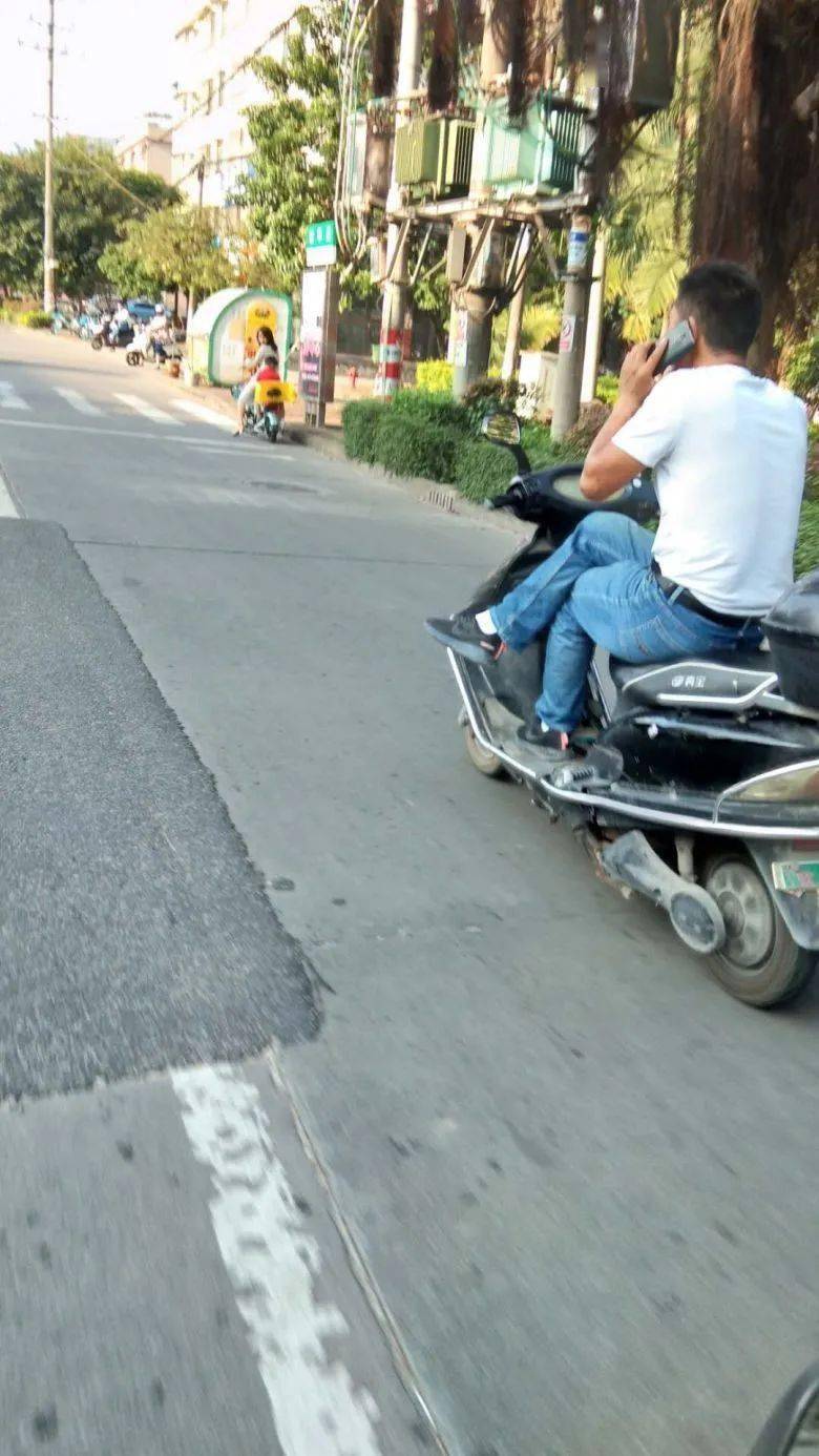 豪横!钦州一妹子跷二郎腿单手开电动车,还低头刷手机