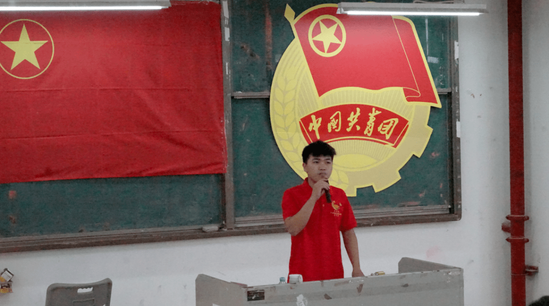 老团员为新团员佩戴团徽
