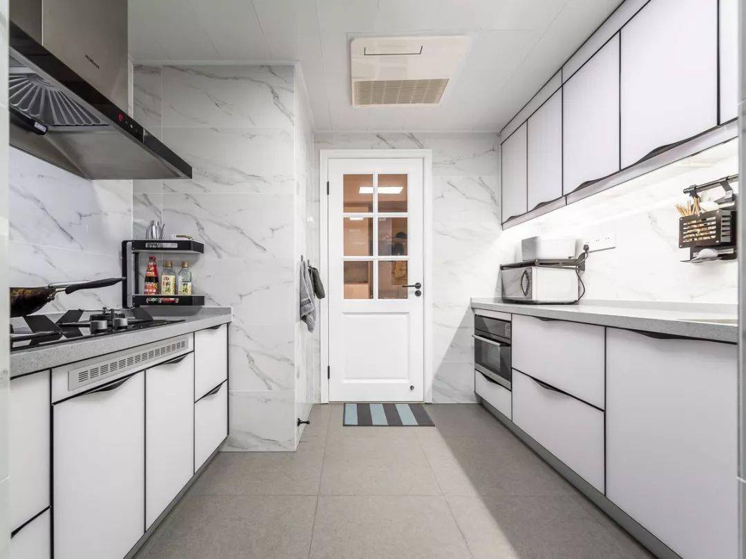 厨房以灰色地砖 雅白墙面砖,搭配白色的橱柜,二字型的厨房操作台