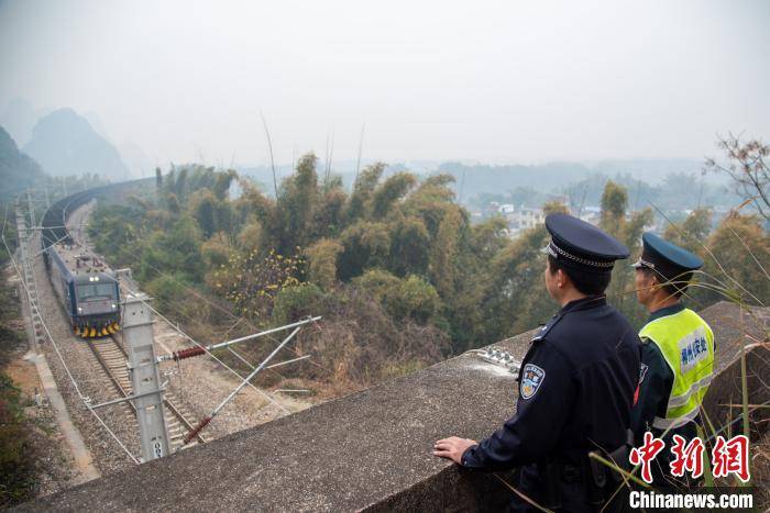 王以照 摄  1月21日,"90后"铁路民警易峰正和护路队员李运武,在广西