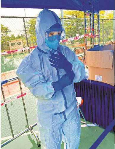南方科技大学医院体检科护士长何素芳穿好防护服准备投入工作.