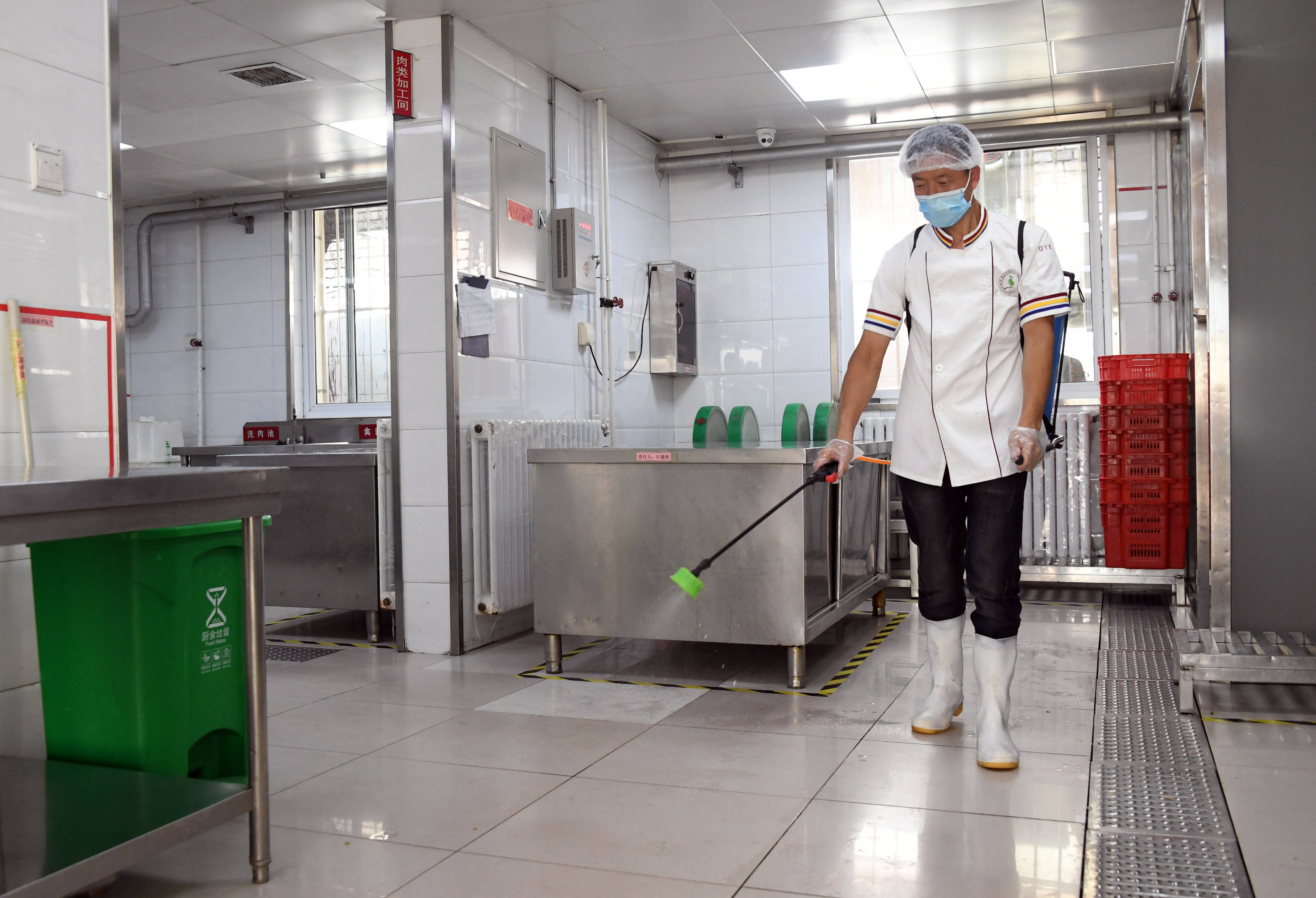 8月26日,在北京市海淀区太平路小学,工作人员对食堂厨房进行消毒.