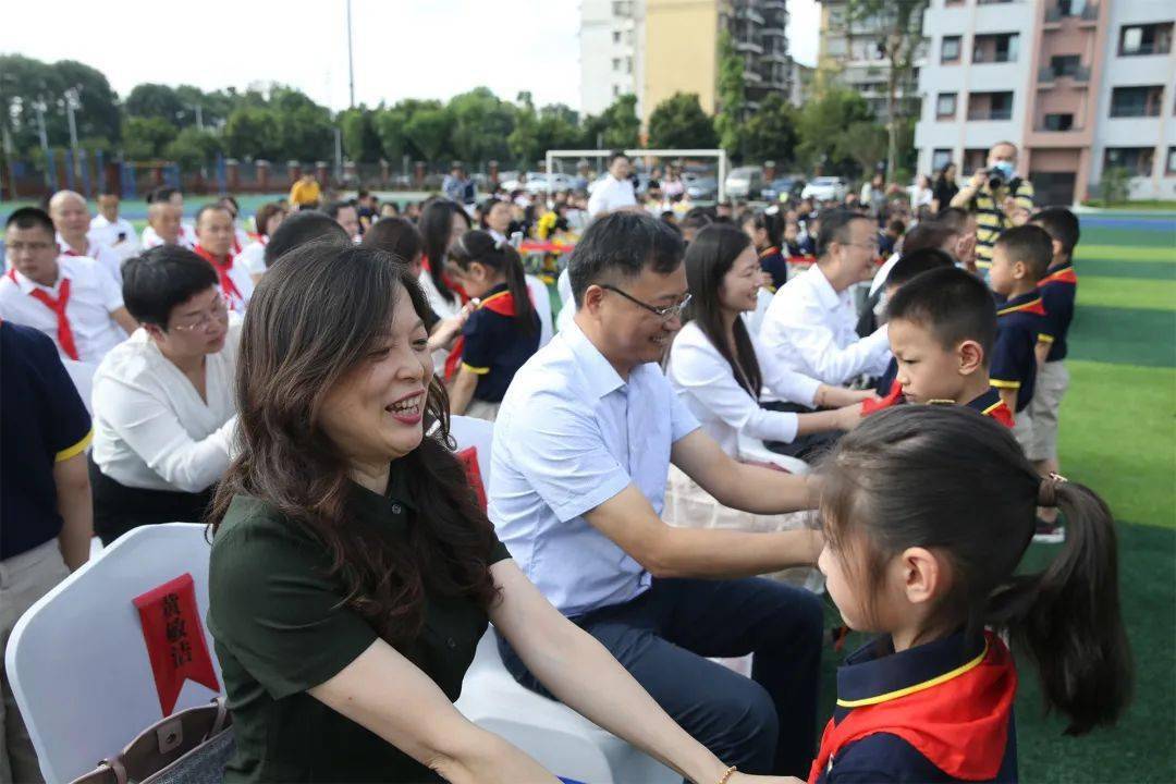 来宾为文君小学新生代表佩戴校徽成都师范附属小学邛崃文君分校校长
