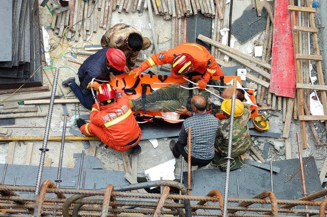 一名工人平躺在工地上, 救援人员询问是否还有其他部位受伤, 在确认