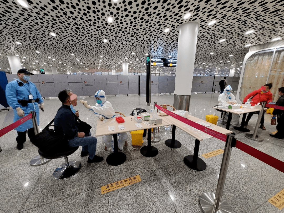 乘客在深圳机场内接受落地核酸检测.