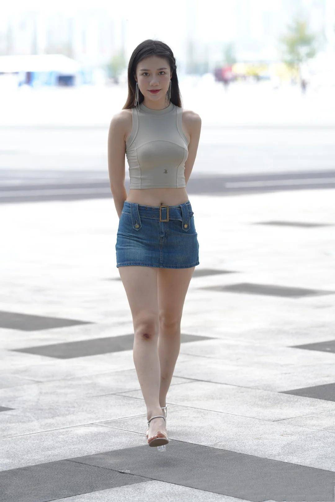 弧度 短款无袖背心搭配牛仔短裙，凸显香肩、小蛮腰和美腿，魅力炸街