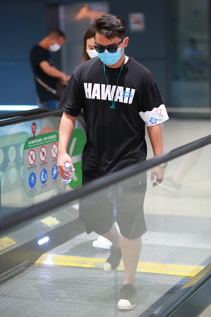 郑恺穿夏威夷字母t恤配短裤 拎水瓶搭机走姿太潇洒