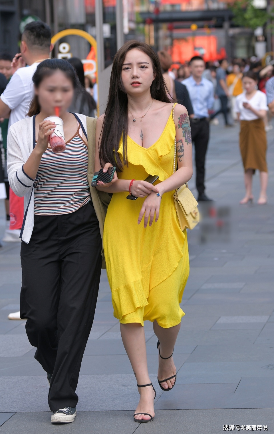 美女街拍:花臂小姐姐穿上黄色的吊带低胸裙,露出迷人的事业线!