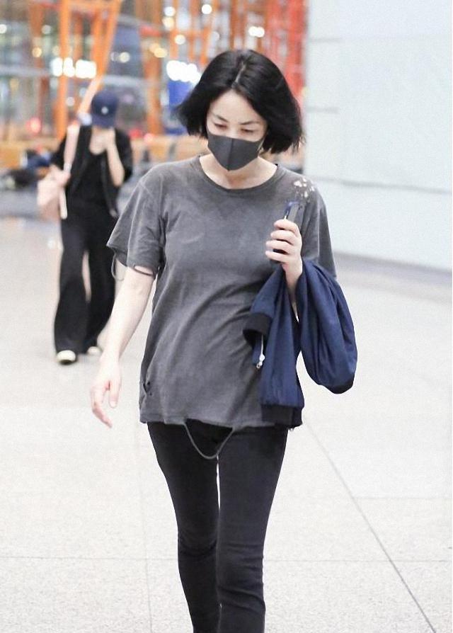 原创王菲素颜走机场,穿做旧破洞t恤配黑色紧身裤,50岁的身材似少女
