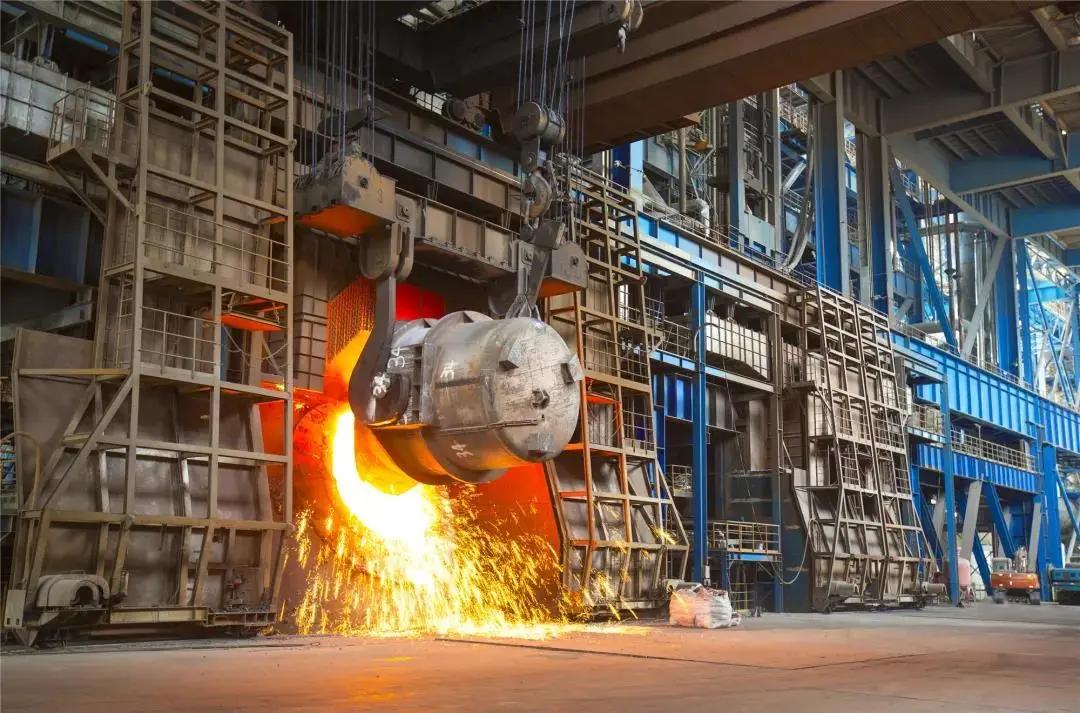 在转炉三区炉台现场,火红的铁水从铁包倒入转炉中,一瞬间,火红的炉火