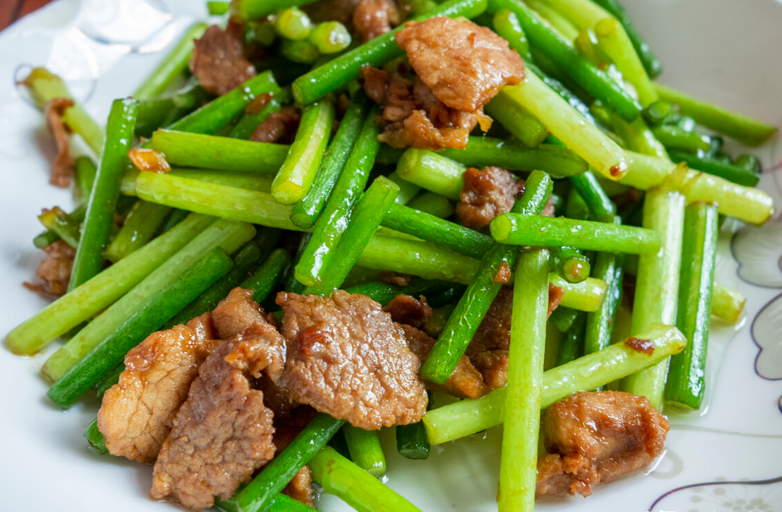 冒烟后,放入肉片翻炒,变色变硬后即可推到一旁;4,倒入切好的蒜苔,煸炒