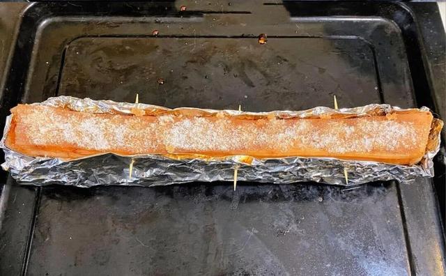 5, 五花肉皮朝上,包入锡纸中,用牙签或叉子在肉皮上扎上小眼儿.