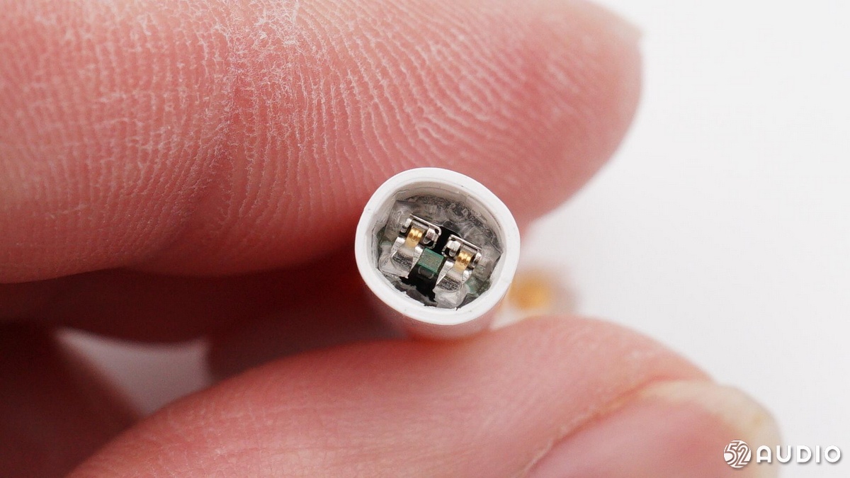 条形主板底部是连接充电触点的金属弹片,耳机柄底部有胶水密封.