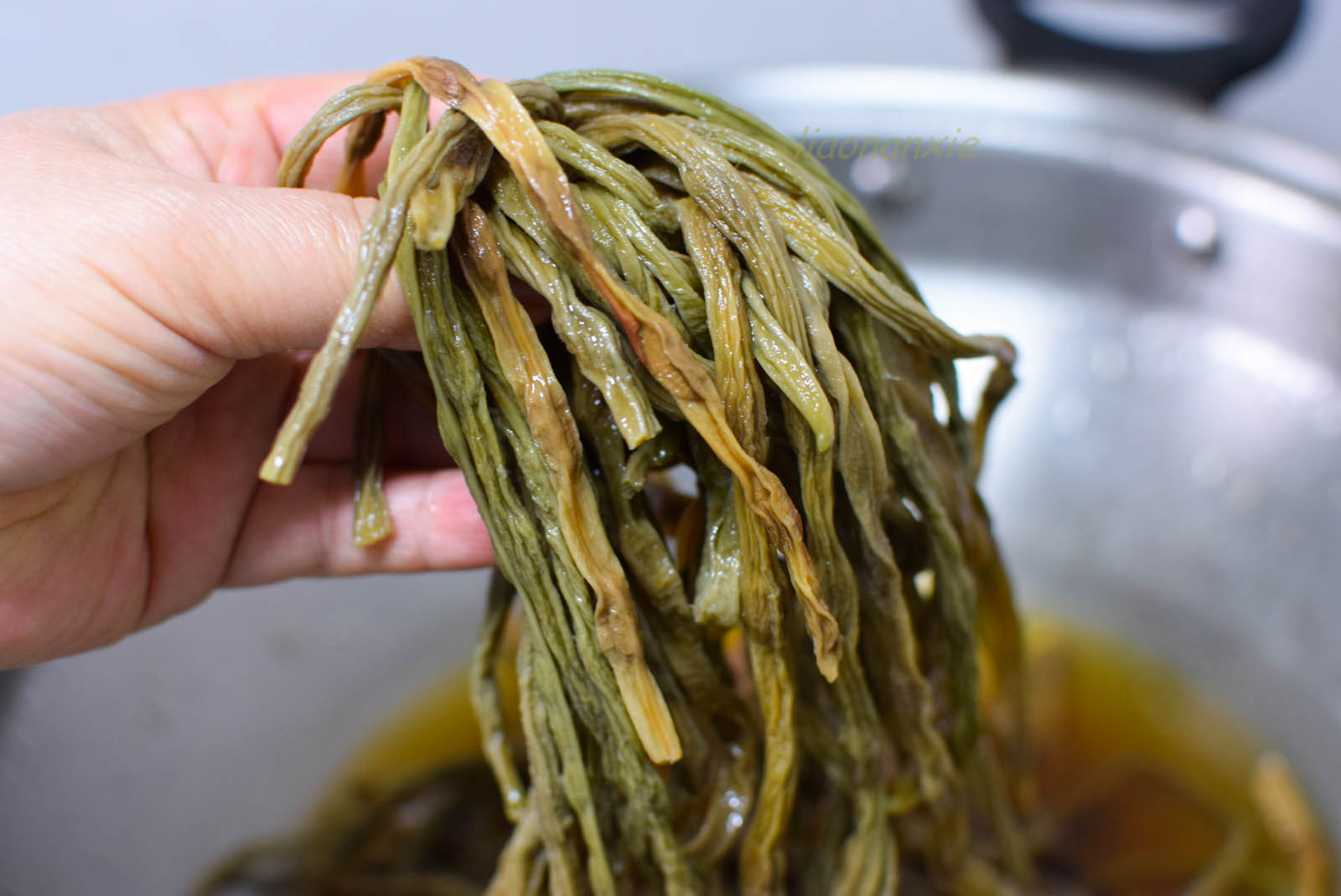 泡好的豆角切成段,蒜苗也切成段备用.