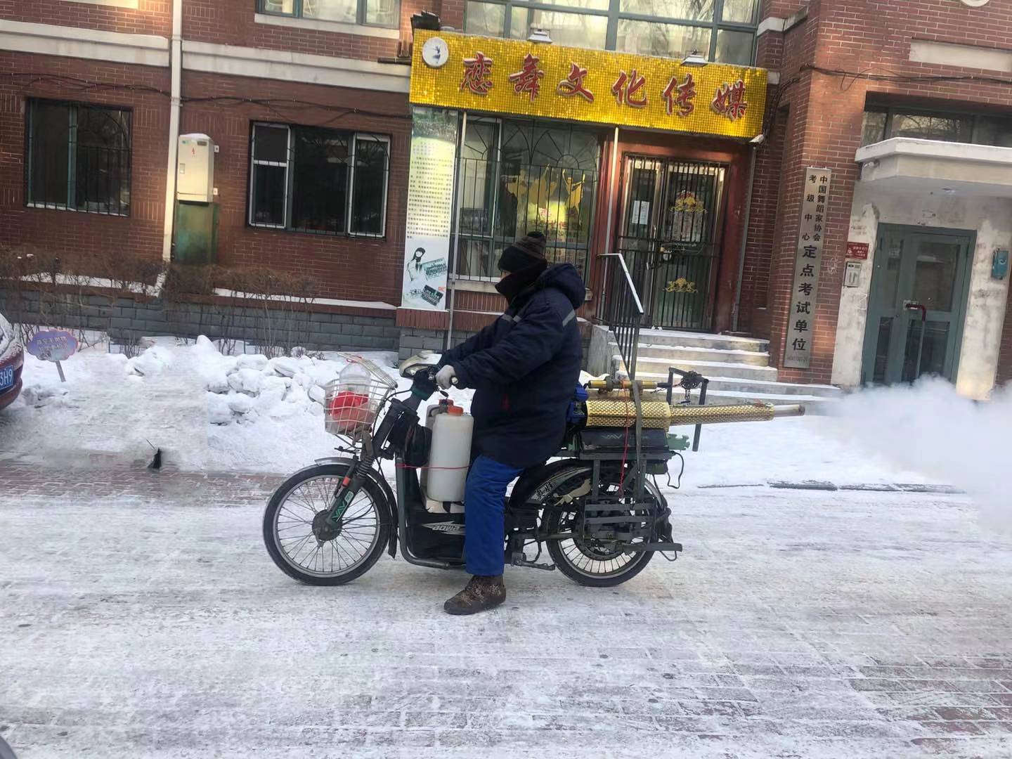 哈尔滨香坊区防疫员寒风中骑行6小时,消毒炮喷到小区各角落
