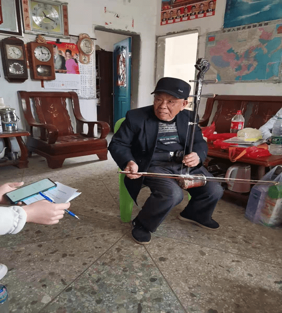 图为李就先生在表演拉二胡