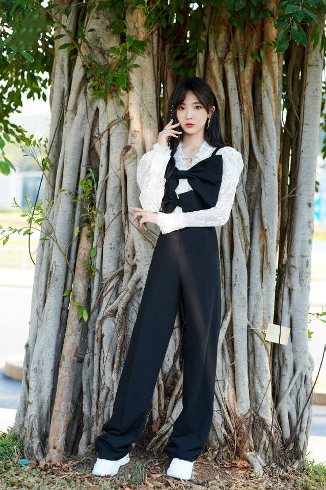 她穿着黑色西装裤超显腿长,再配上画龙点睛的发饰,戴着心形的眼镜也