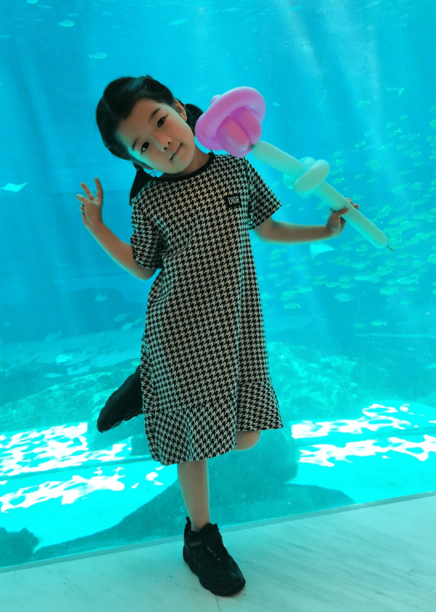 王栎鑫大女儿王唯伊已经出落成一个5岁的漂亮小姑娘了,一边拿着气球