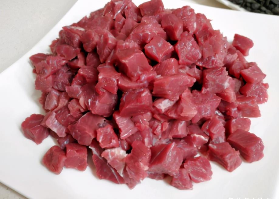 制作过程:第一步,牛里脊肉切丁,生姜切末,牛肉粒中加上姜末,酱油,白糖