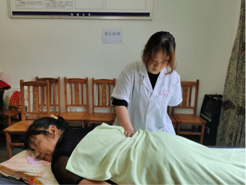 图为志愿者在为村民进行腰部推拿手法治疗.邓邵君 摄
