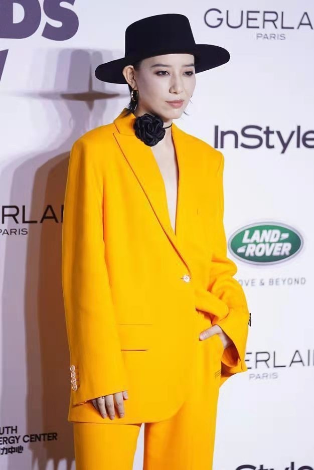 中性|李斯丹妮打扮过于个性，穿亮黄西装脖子上系一朵黑花，搭配好新潮