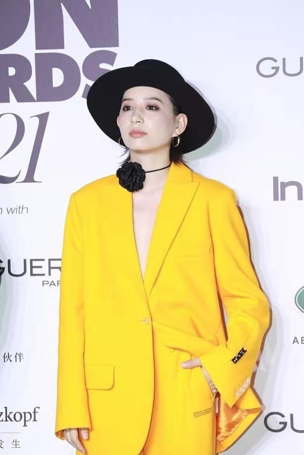 中性|李斯丹妮打扮过于个性，穿亮黄西装脖子上系一朵黑花，搭配好新潮