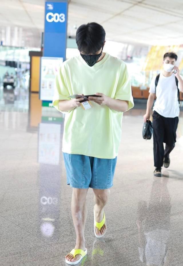李荣浩|李荣浩够任性的,脚踩人字拖现身机场,边玩游戏超显轻松自在