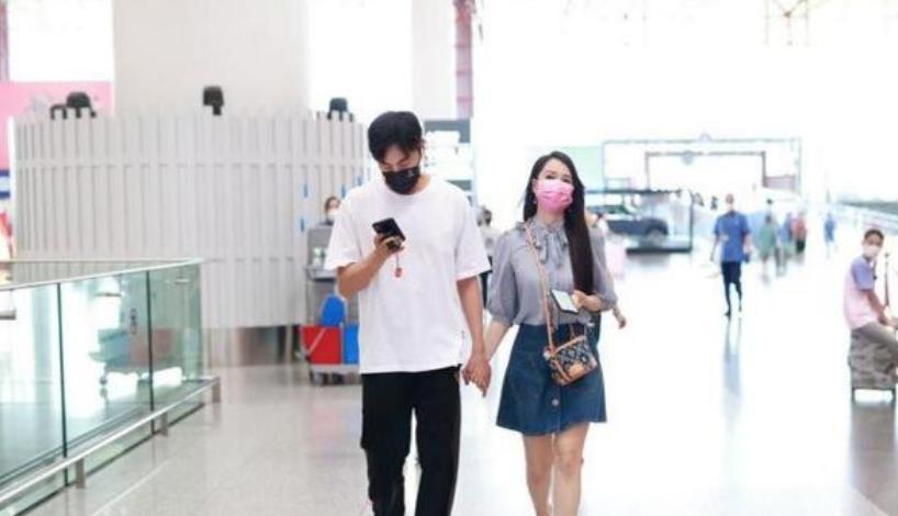 短裙 伊能静跟老公机场甜蜜牵手，穿蝴蝶衬衫配短裙，看着比秦昊还年轻