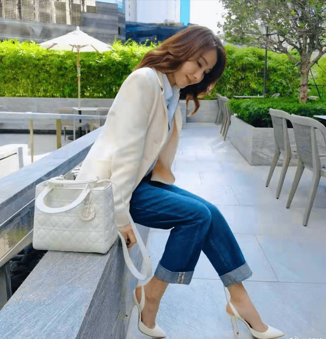 黎姿再搭配阔腿九分牛仔裤,整体版型在视觉上都是"直筒型",非常干练