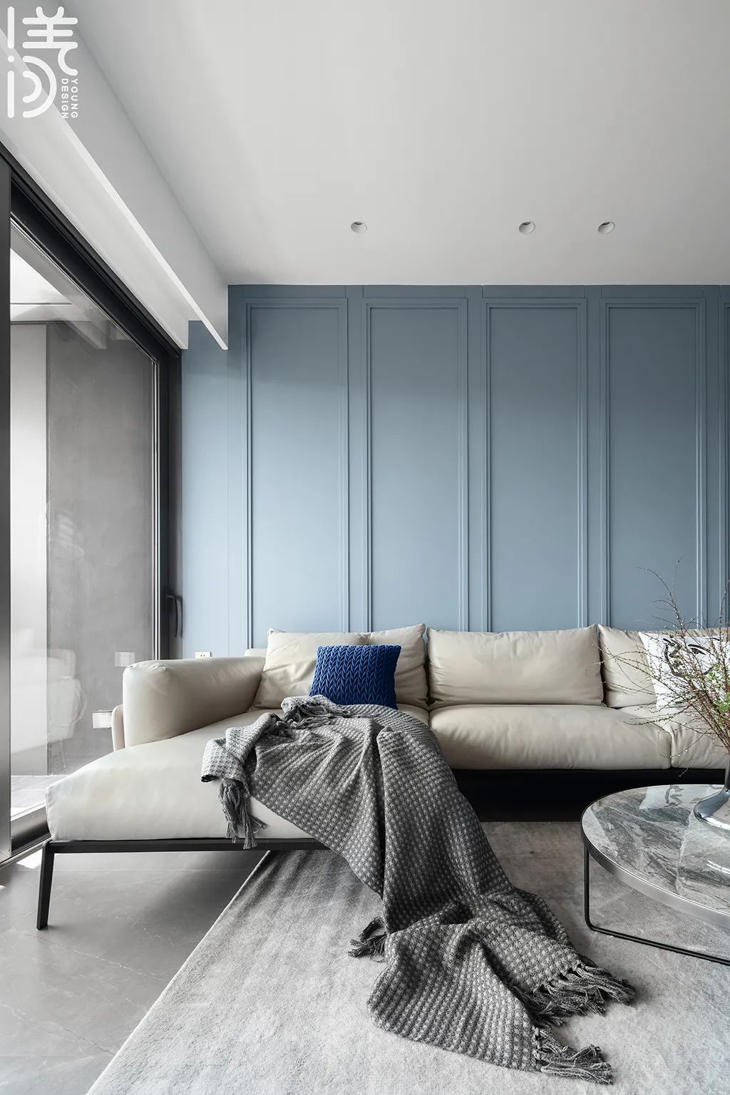 沙发墙是蓝色的护墙板,边框造型让空间显得层次更加丰富,布置灰白色
