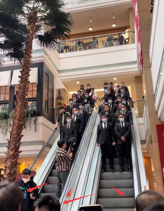 胡兵从二楼下电梯进入活动现场,身边站满了保镖,电梯下面也有一排保镖