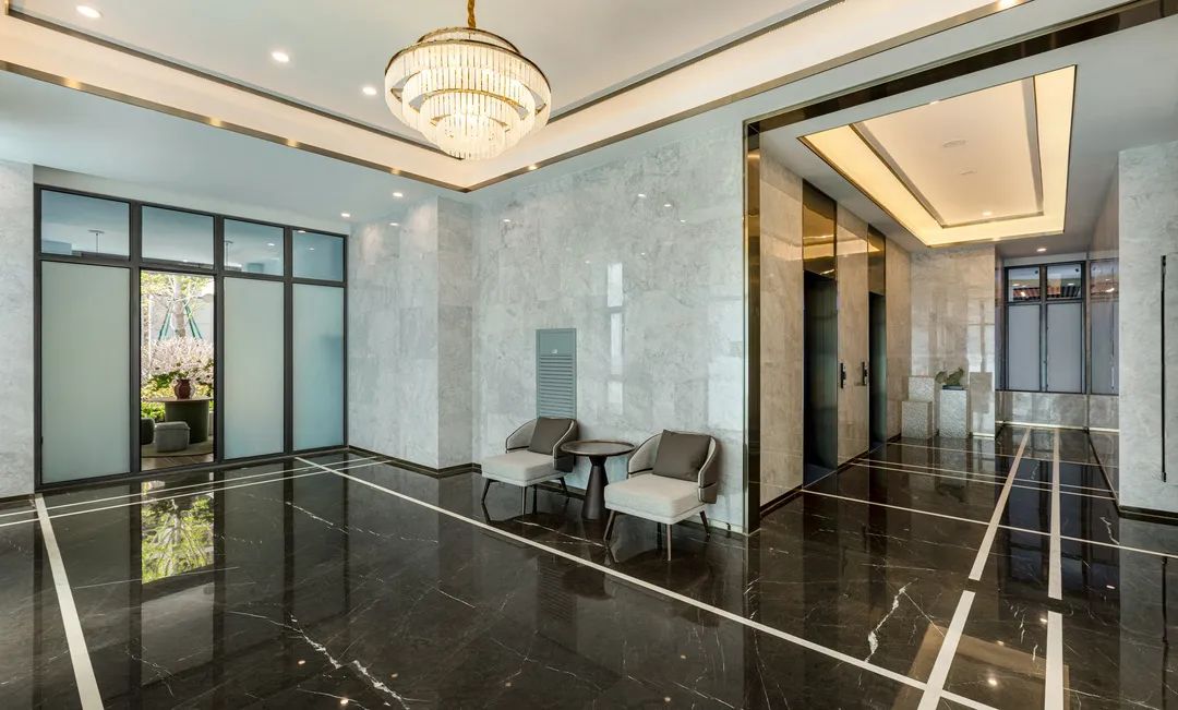 进入楼栋内,挑高的入户大堂上一缕温和的水晶灯光.