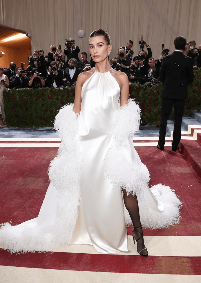 海莉比伯身着紧身白色礼服搭配羽毛饰边外套尽显优雅气质与魅力