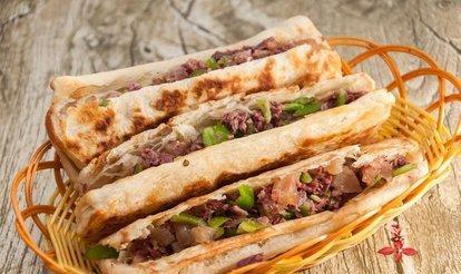 将面团擀成圆饼,并在上面涂一层起酥油,然后卷起来.