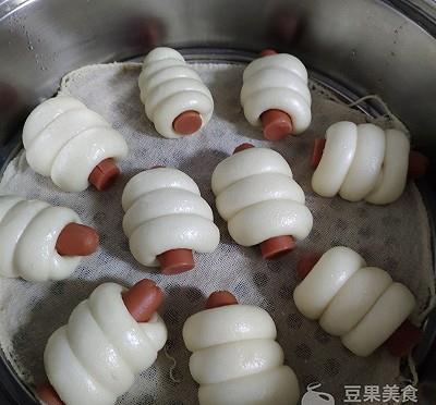10,蒸好以后取出.11,准备好芝麻.12,热狗卷底部喷一层清水,蘸满芝麻.