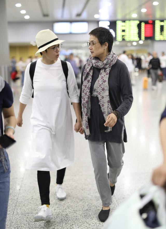 蒋雯丽姐妹就活得自信又潇洒,蒋雯丽的姐姐穿着一件深灰色的t恤,下身