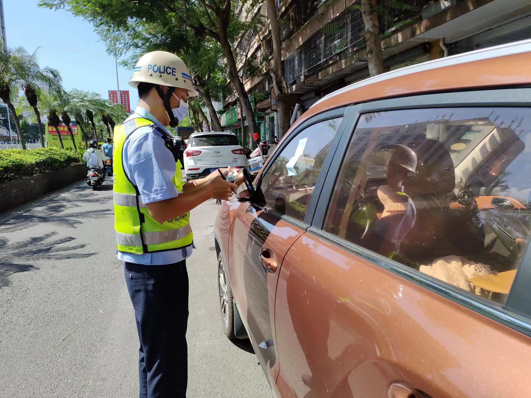 圖為:加強機動巡邏,查處亂停亂放行為.圖為:張貼違法停車告知單.