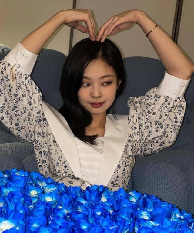 blackpink成员jennie生日,抱蓝色玫瑰笑眼弯弯,苹果肌上扬真美_妮妮